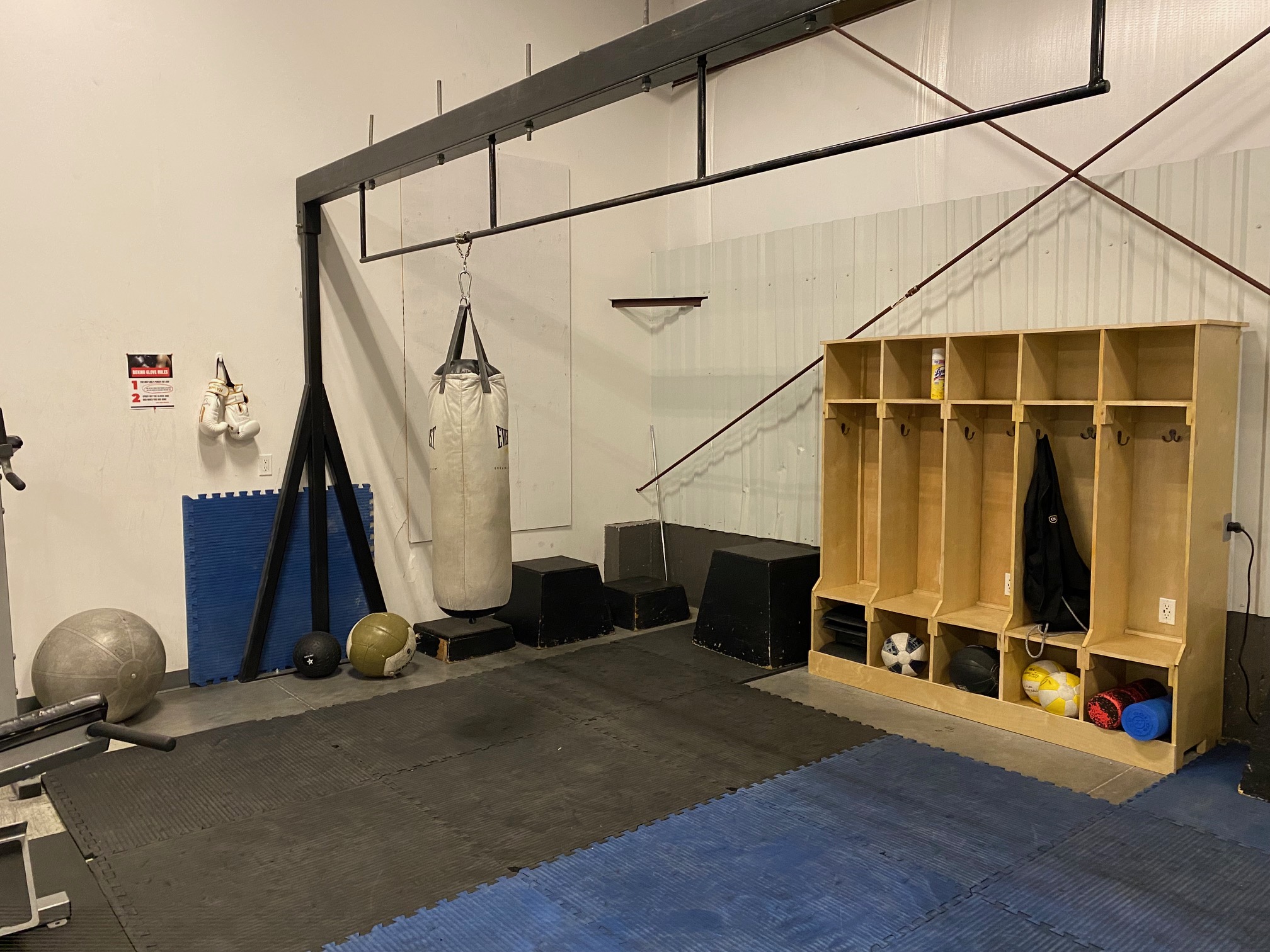 Punching bag with pullup bars with cubbies to store jackets and gym bags in the back